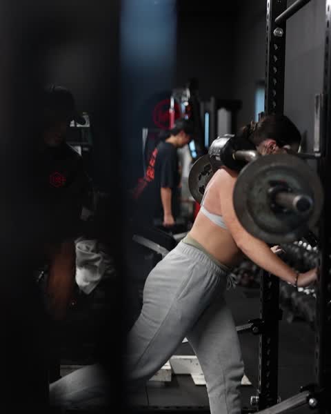 Client working a barbell exercise in the rack